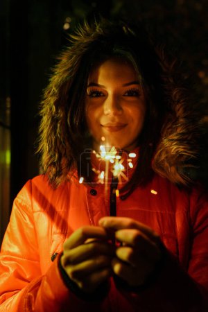 Photo for Girl holding burning sparkler during Christmas - Royalty Free Image