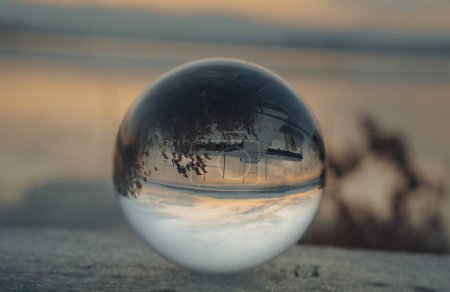 Photo for View of nature through a glass ball, summer sunset time. crystal glass ball against nature background with reflections - Royalty Free Image