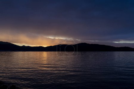 Téléchargez les photos : Mer calme avec coucher de soleil et montagnes - en image libre de droit