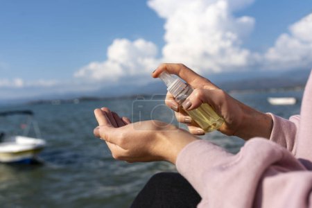 Téléchargez les photos : Une femme tenant une bouteille de parfum dans sa main - en image libre de droit