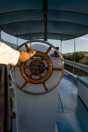 Téléchargez les photos : Homme au volant d'un voilier. Homme tenant les mains sur le gouvernail du navire et navigue. - en image libre de droit
