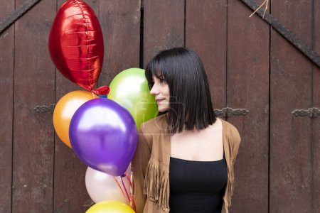 Photo for Young woman holding a bunch of balloons - Royalty Free Image