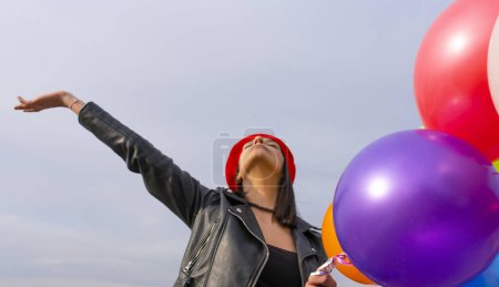 Téléchargez les photos : Jeune femme au béret rouge tenant un tas de ballons - en image libre de droit