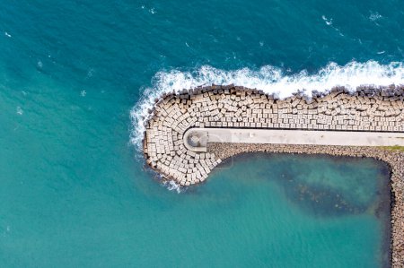 Aerial view of the sea stone breakwater. Beautiful ocean wallpaper for tourism and advertising.
