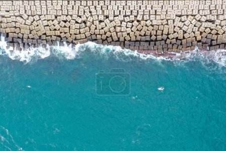 Aerial view of the sea stone breakwater. Beautiful ocean wallpaper for tourism and advertising.