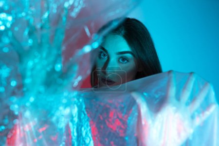 Photo for High Fashion model woman in colorful bright neon blue and purple lights posing in studio. Portrait of beautiful girl with trendy glowing make-up. Art design vivid style On colourful vivid background - Royalty Free Image