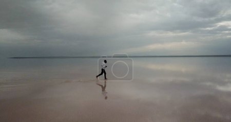 Photo for African american man running over sea on the beach - Royalty Free Image