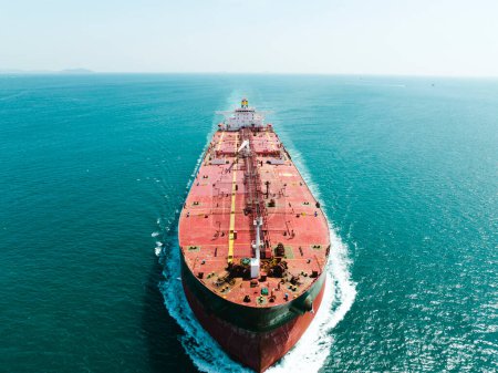 Aerial view of a large, loaded container cargo ship traveling over open ocean