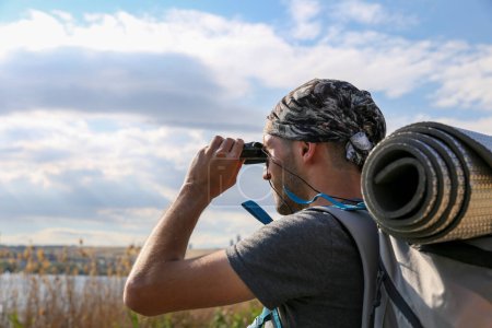 Photo for Young male traveler with binoculars on background - Royalty Free Image