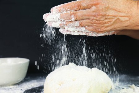 Photo for Female hands making dough for bread on  background - Royalty Free Image