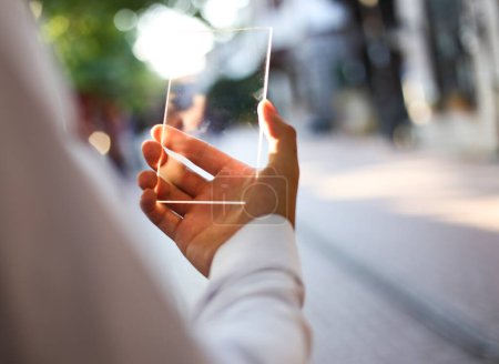 Téléchargez les photos : Homme utilisant smartphone transparent futuriste en ville - en image libre de droit