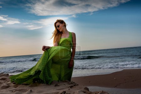 Téléchargez les photos : Femme heureuse marchant sur la plage au coucher du soleil.Belle femme heureuse se détendre marchant sur la plage près de la mer lorsque le coucher du soleil dans la soirée. - en image libre de droit