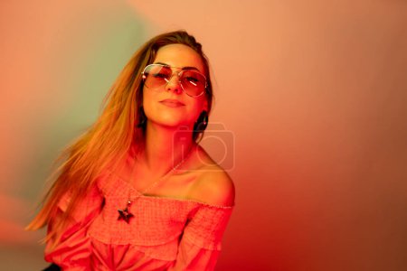 Photo for High Fashion model woman in colorful bright neon blue and purple lights posing in studio. Portrait of beautiful woman with trendy glowing make-up. Art design vivid style - Royalty Free Image