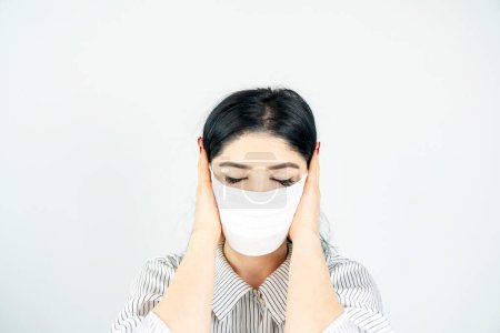 Photo for Young woman with surgical mask on face against SARS-CoV-2. COVID-19 Pandemic Coronavirus Young girl in white room wearing face mask - Royalty Free Image