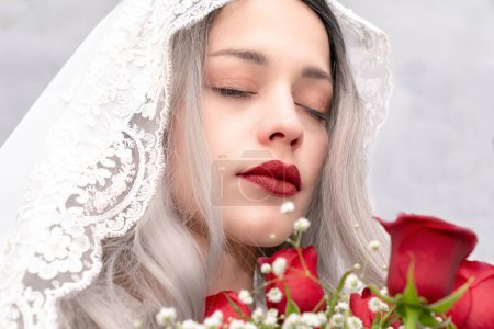 Téléchargez les photos : Belle femme tenant un bouquet de roses rouges et portant un voile blanc - en image libre de droit