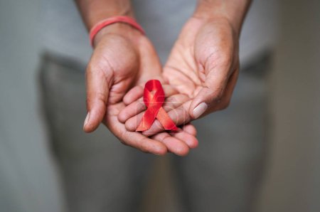 Téléchargez les photos : Mondes Journée mondiale du sida, Les hommes tiennent un ruban rouge Dans sa main, Sensibilisation au VIH / sida, Gros plan sur les hommes tenant un ruban rouge sur fond blanc Concept VIH / sida, Concept Santé - en image libre de droit