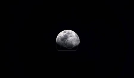 Foto de Earth's Moon Glowing On Black Background. Waning Gibbous moon / Waning means that it is getting smaller. Gibbous refers to the shape, which is less than the full circle of a Full Moon - Imagen libre de derechos
