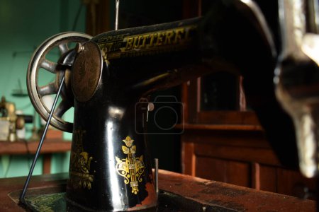 Téléchargez les photos : Tuban, Indonésie - 7 septembre 2023 : Une machine à coudre papillon antique sur le bureau en bois. Vintage, Vieux, Machine à coudre rétro - en image libre de droit