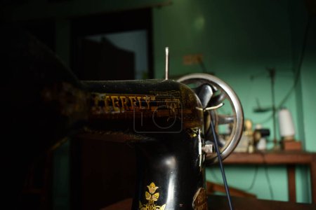 Foto de Tuban, Indonesia - 7 de septiembre de 2023: Una máquina de coser de mariposa antigua en el escritorio de madera. Vintage, viejo, máquina de coser retro - Imagen libre de derechos