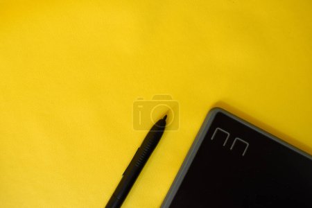 Photo for Flat lay of cropped graphic creative pen tablet, with copy space on yellow background - Royalty Free Image