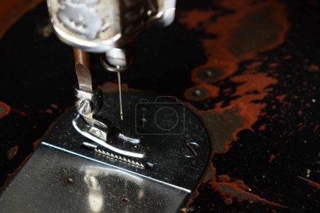 Foto de Máquina de coser de cerca con aguja en la mesa de madera, máquina de coser antigua con polvo - Imagen libre de derechos