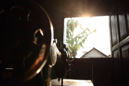 Téléchargez les photos : Roue de machine à coudre antique roue avec lumière du soleil sur le bois de table - en image libre de droit