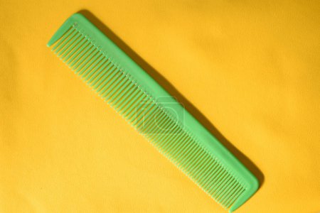 Foto de Un peine verde aislado sobre fondo amarillo - Imagen libre de derechos
