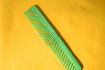 Photo for A green comb isolated on yellow background - Royalty Free Image