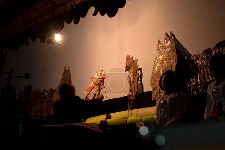 Foto de Un hombre actúa con wayang o títeres tradicionales de Java en el escenario por la noche. Tuban, Indonesia - 22 de septiembre de 2023. - Imagen libre de derechos