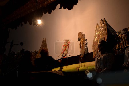 Téléchargez les photos : Un homme joue avec wayang ou marionnette traditionnelle javanaise sur scène la nuit. Tuban, Indonésie - 22 septembre, 2023. - en image libre de droit