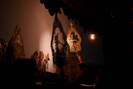Foto de Un hombre actúa con wayang o títeres tradicionales de Java en el escenario por la noche. Tuban, Indonesia - 22 de septiembre de 2023. - Imagen libre de derechos