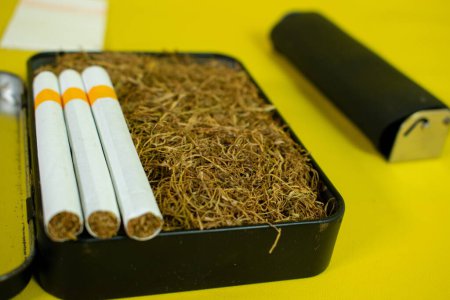 Téléchargez les photos : Tabac et cigarette en boîte noire, rouleau à cigarettes fait à la main - en image libre de droit