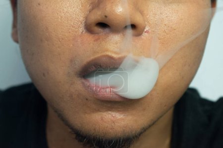 Téléchargez les photos : Bouche d'un homme plein de fumée, un homme fumant - en image libre de droit