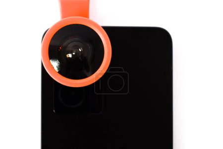 Téléchargez les photos : Gros plan Clip sur lentille fisheye sur smartphone noir, extension lentille oeil de poisson sur caméra smartphone isolé sur fond blanc - en image libre de droit