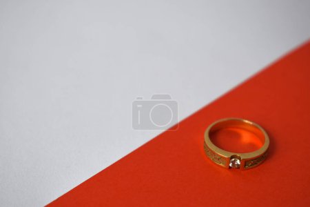 Téléchargez les photos : Fermer Bague dorée avec diamant sur fond blanc et orange en diagonale - en image libre de droit