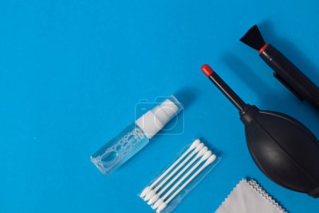 Foto de Set de limpieza para soplador de aire de cámara, microfibra, cepillo y más. Aislado sobre fondo azul - Imagen libre de derechos