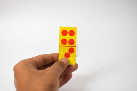 Téléchargez les photos : Main tenir dominos jouer cartes isolé fond blanc, jaune rouge dominos cartes - en image libre de droit