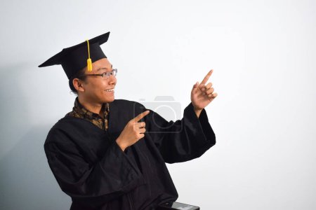 Foto de Expresivo de indonesia adulta ropa de graduación masculina, sombrero y anteojos aislados sobre fondo blanco, expresiones de graduación de retrato - Imagen libre de derechos