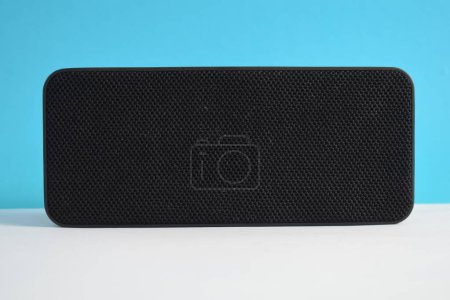 Foto de Caja de altavoces inalámbrico negro para reproducir música sobre fondo azul, reproductor de música inalámbrico, electrónica. - Imagen libre de derechos