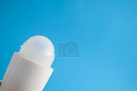 Téléchargez les photos : Bouteille blanche déodorant blanc pour maquette sur fond bleu, maquette de produit, soins de santé des aisselles, soins du corps - en image libre de droit