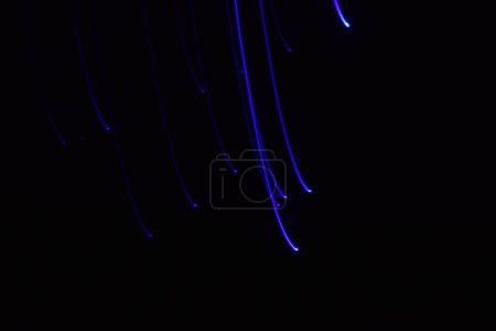 Foto de Larga exposición colorida línea abstracta pintura fondo aislado en negro. líneas curvas de iluminación de tira led sobre fondo negro - Imagen libre de derechos