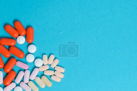 Foto de Píldoras coloridas de la medicina en forma de corazón aislado sobre fondo azul, suplemento, vitamina, colorido - Imagen libre de derechos