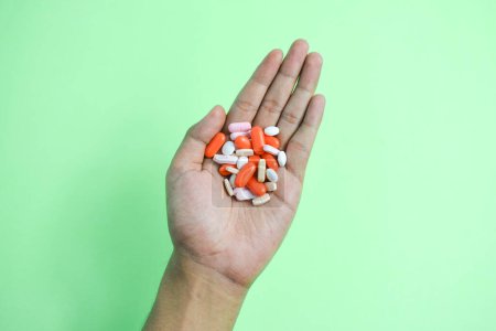 Téléchargez les photos : Pilules de médecine colorée dans la main de l'homme sur fond de degré - en image libre de droit