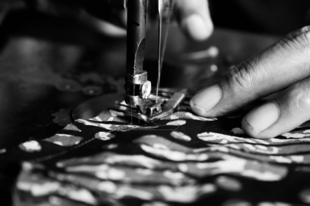 Foto de Vintage Black and White Close up Senior Female Tailor Costura batik tela indonesia en tela, anciano senior y concepto vintage en blanco y negro - Imagen libre de derechos