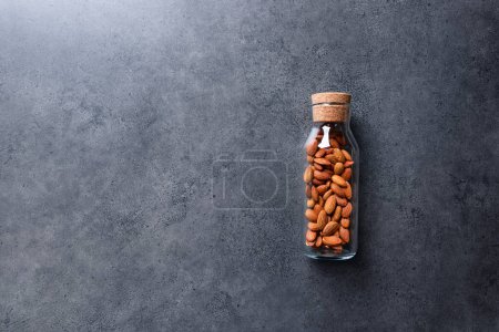 Téléchargez les photos : Almond nuts in a glass jar on a concrete desktop. Top view, with copy space. - en image libre de droit