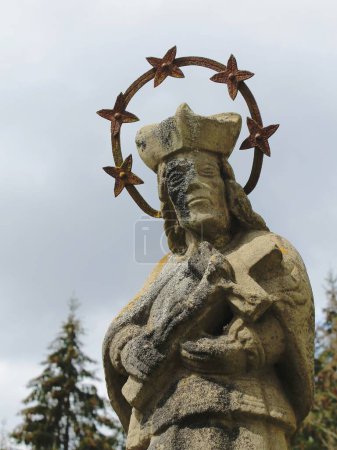 Photo for A statue of a holy man with a cross in an old cemetery - Royalty Free Image