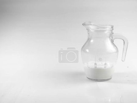 Téléchargez les photos : Concept de fond pour la journée mondiale du lait, image une cruche de verre de lait et des biscuits sur la table, isolé en arrière-plan blanc, espace de copie. - en image libre de droit
