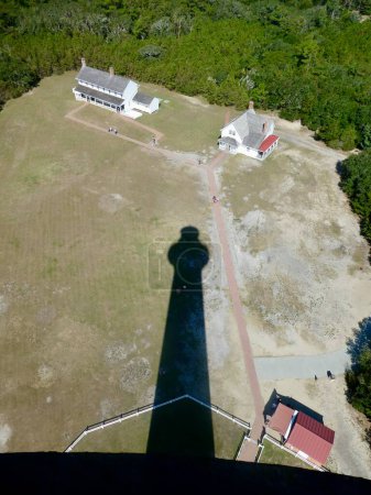 Foto de Buxton, NC, Estados Unidos, 2 de octubre de 2019. La sombra del faro del Cabo Hatteras sobre la casa de los guardianes. - Imagen libre de derechos