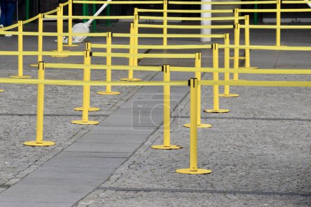 Photo for Yellow queue tape barrier over paved area. Paris, France, March 2023. - Royalty Free Image