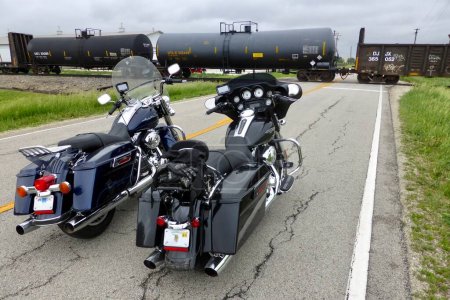 Foto de 2 Black Harley Davidson Motos esperando en un cruce para que pase un tren de carga. Illinois, EE.UU. 4 de junio de 2014. - Imagen libre de derechos